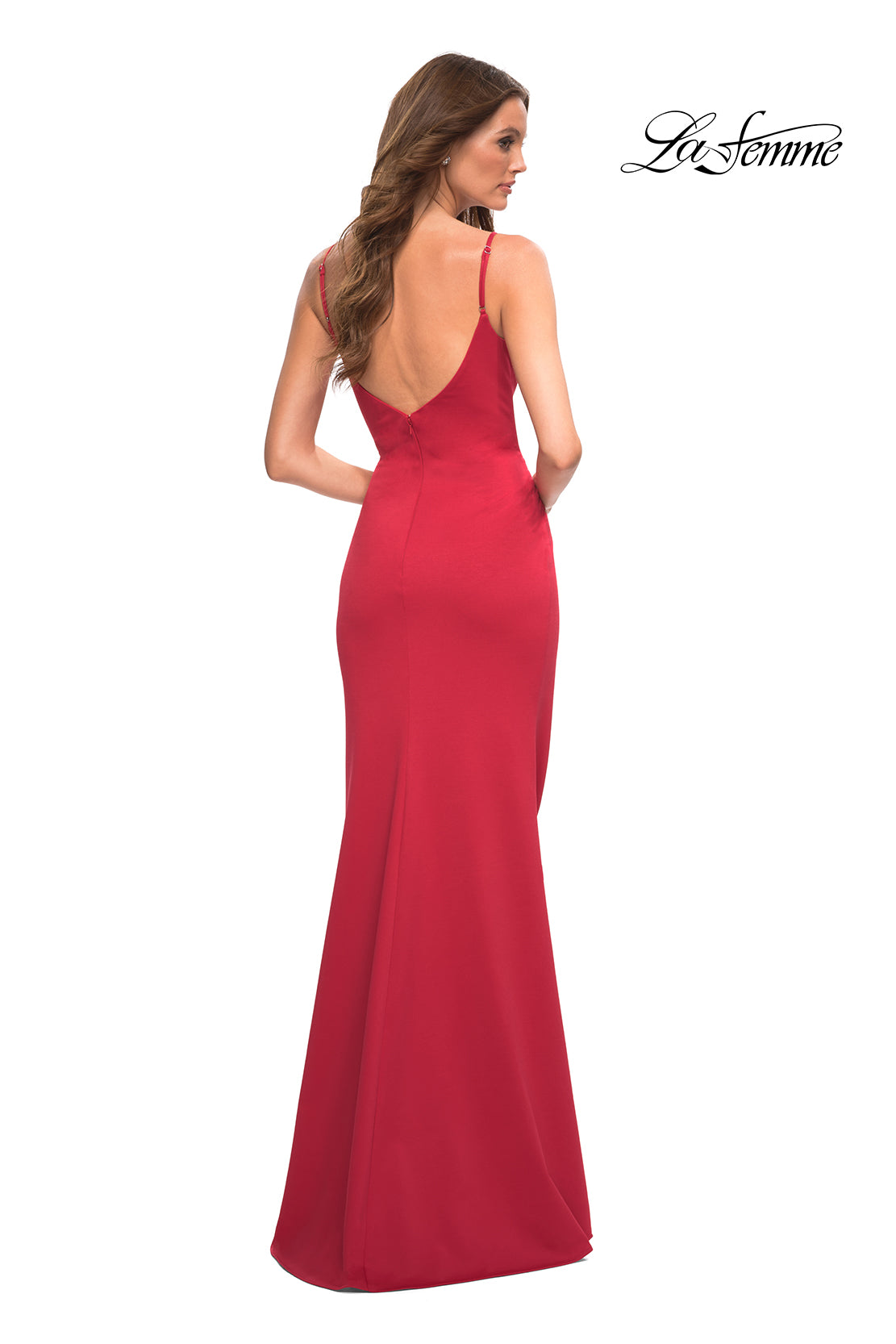 A woman wears the Simple Long V-Neck Prom Dress by La Femme, a sleeveless, floor-length red gown with a low back. She stands with her back to the camera as the La Femme logo appears in the top right corner.
